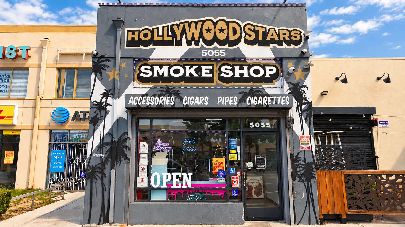 The Hollywood Stars Smoke Shop storefront at 5055 Hollywood Blvd, with gold lettering, painted palms and stars